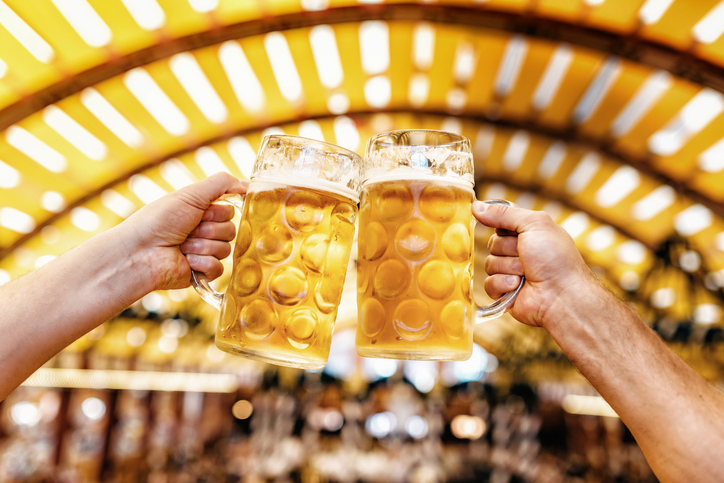 male hands clinking beer glasses at oktoberfest in munich