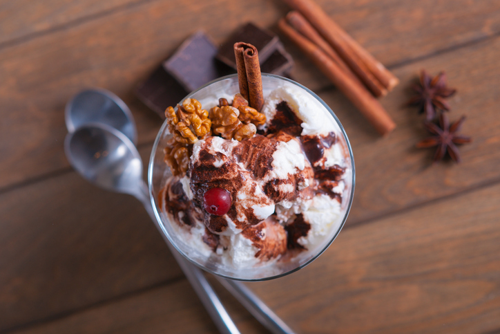 Ice cream sundae with cranberry, spices, spoons and chocolate pieces