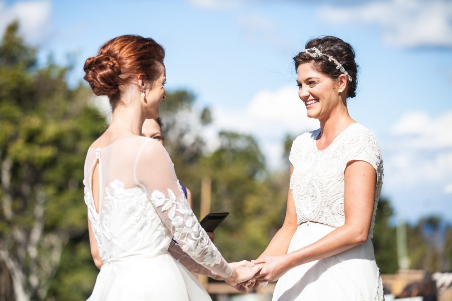 Two brides stand at the altar at their same sex wedding ceremony