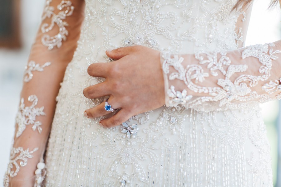bride shows off her elegant engagement ring while wearing a beautiful wedding gown