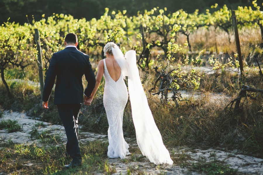 Bride and groom in a vineyard walking