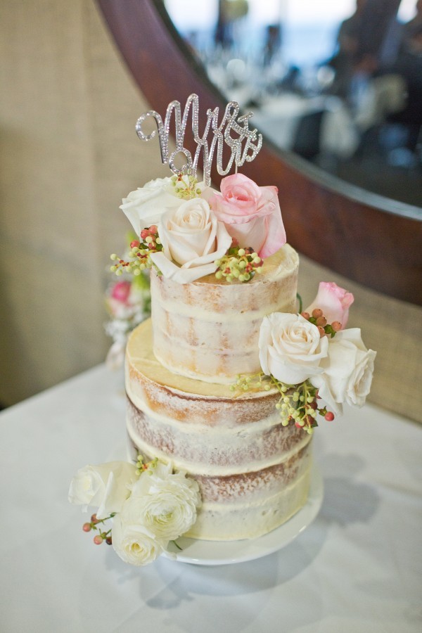 Wedding cake with wedding cake topper and roses