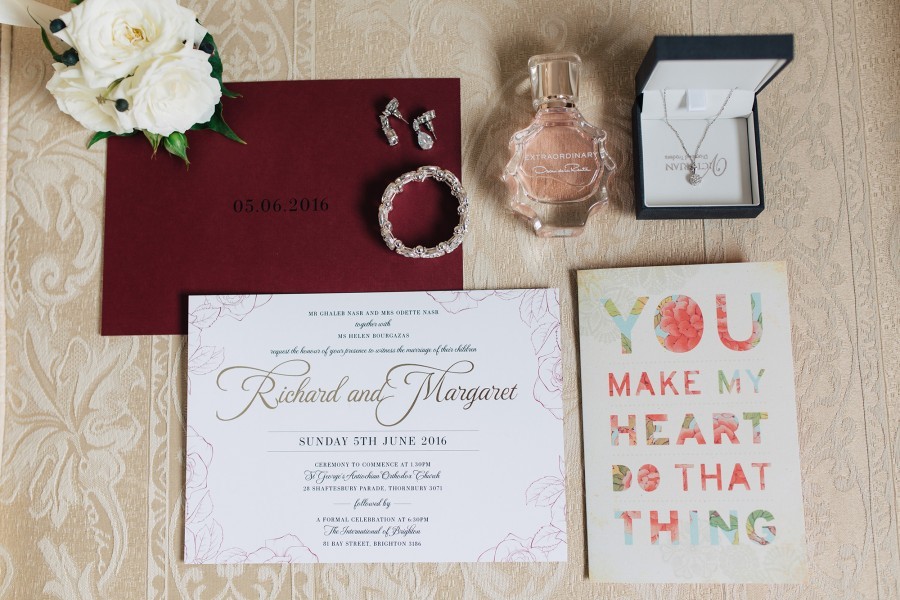 flatlay of wedding invitations, cards jewlery and flowers