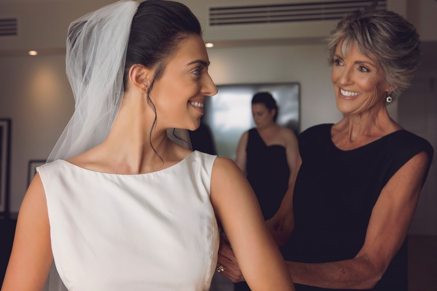 Brides mother helps her to get ready. 