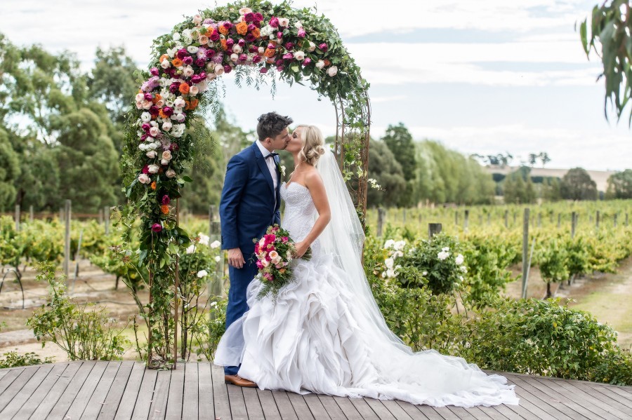 bride and groom kiss at the altar