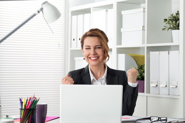 Portrait of happy businesswoman celebrating something with arms