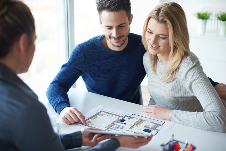 Saleswoman showing paperwork to couple