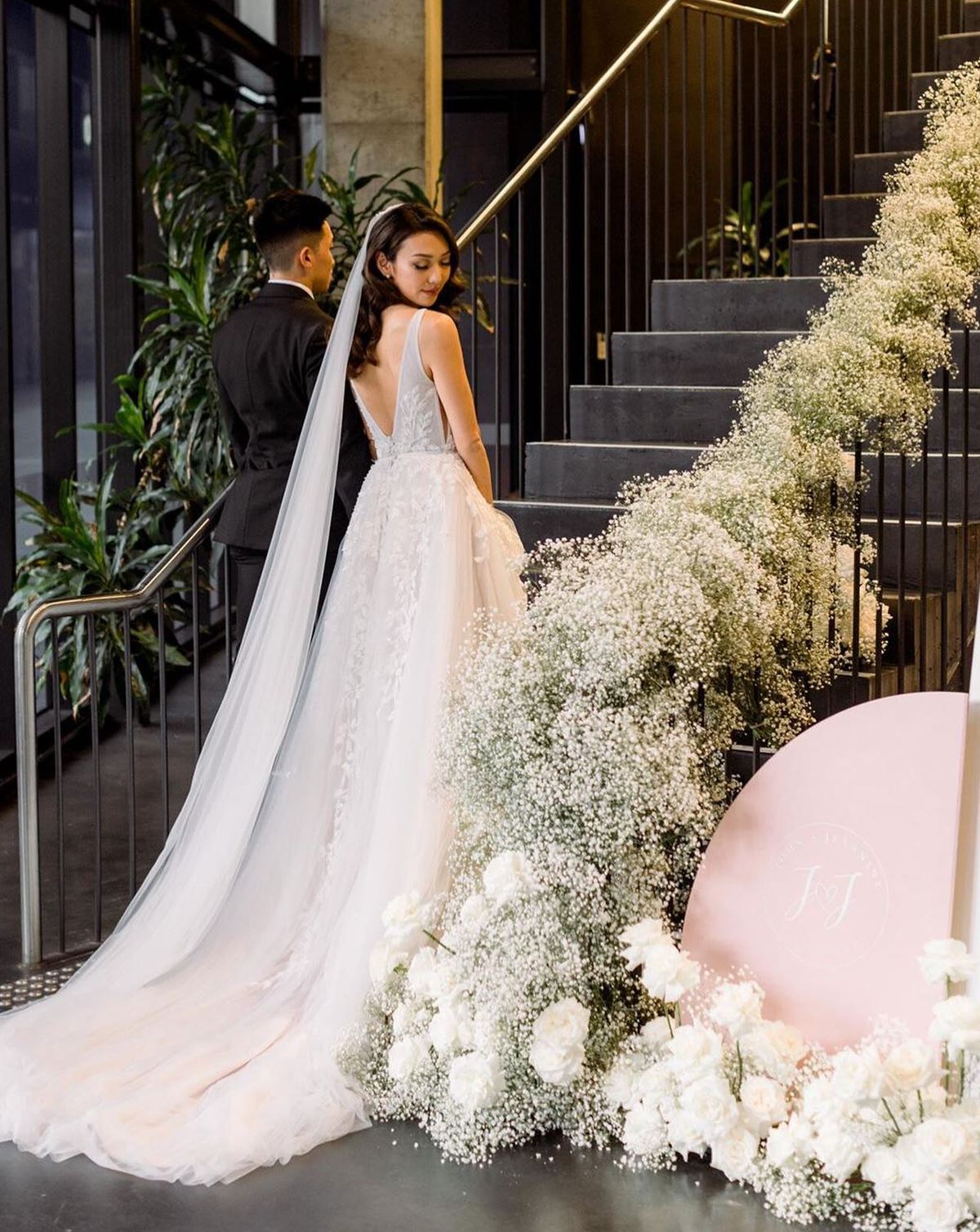 Baby's breath adorning stairs with big train wedding dress