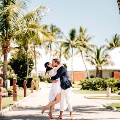 Couple kissing in a tropical setting with palm trees