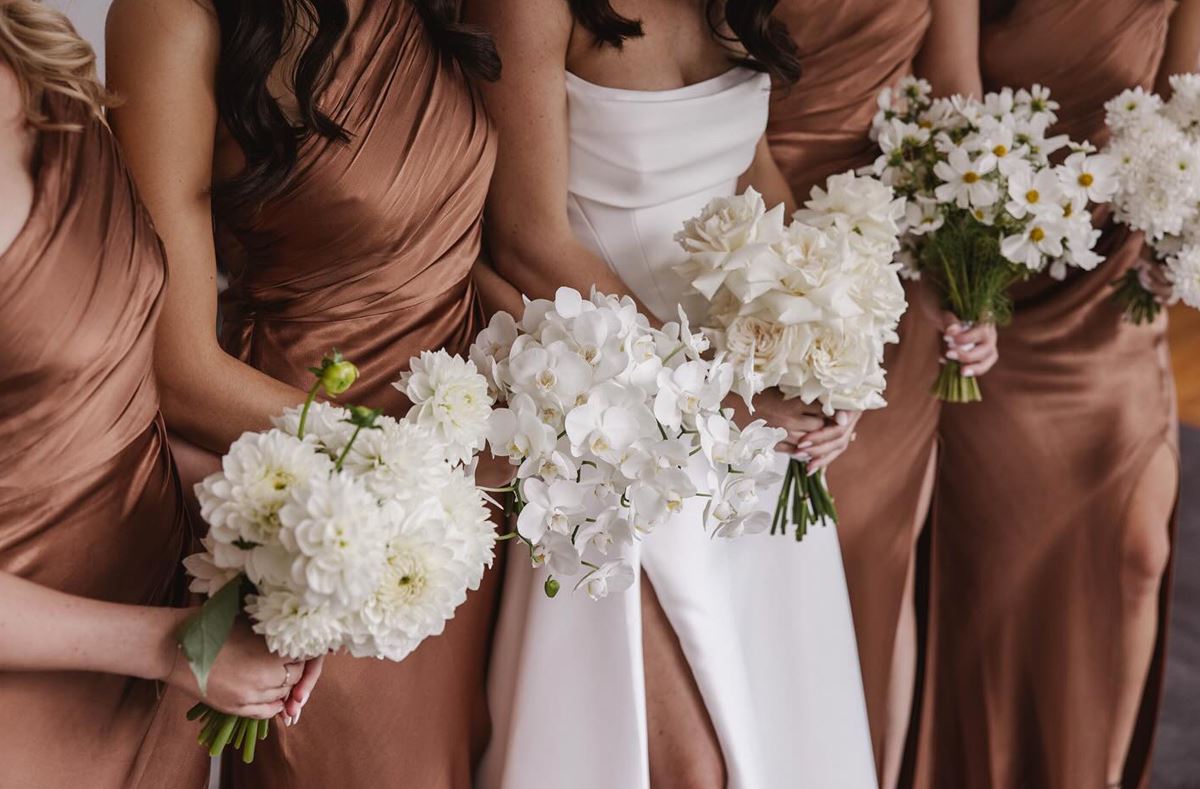 Each bridesmaid holds a subtly different bouquet.