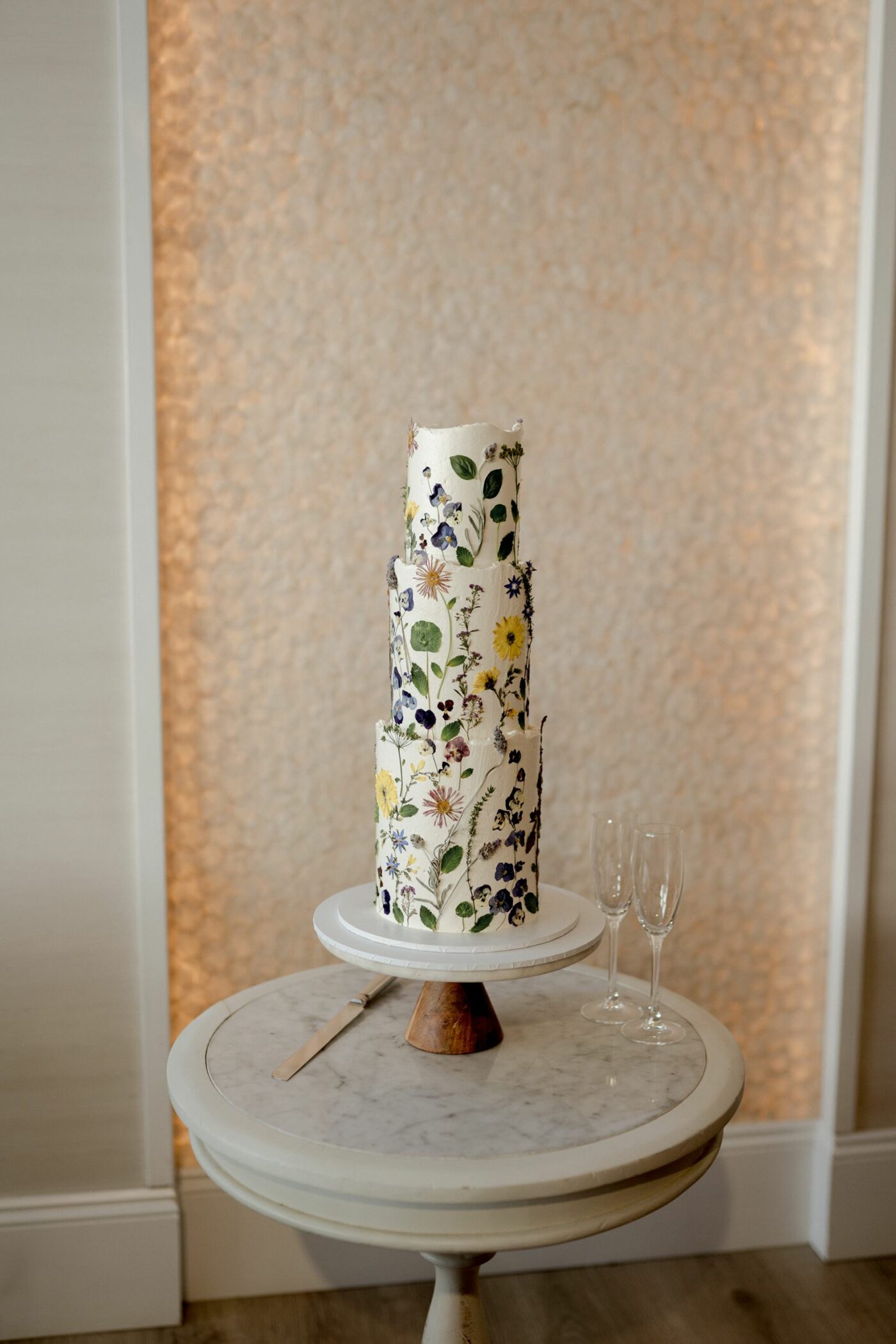 bride cuts her wedding cake with family