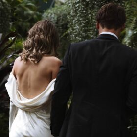 Bride and groom with leaves and trees from behind