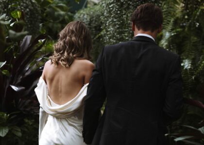 Bride and groom with leaves and trees from behind