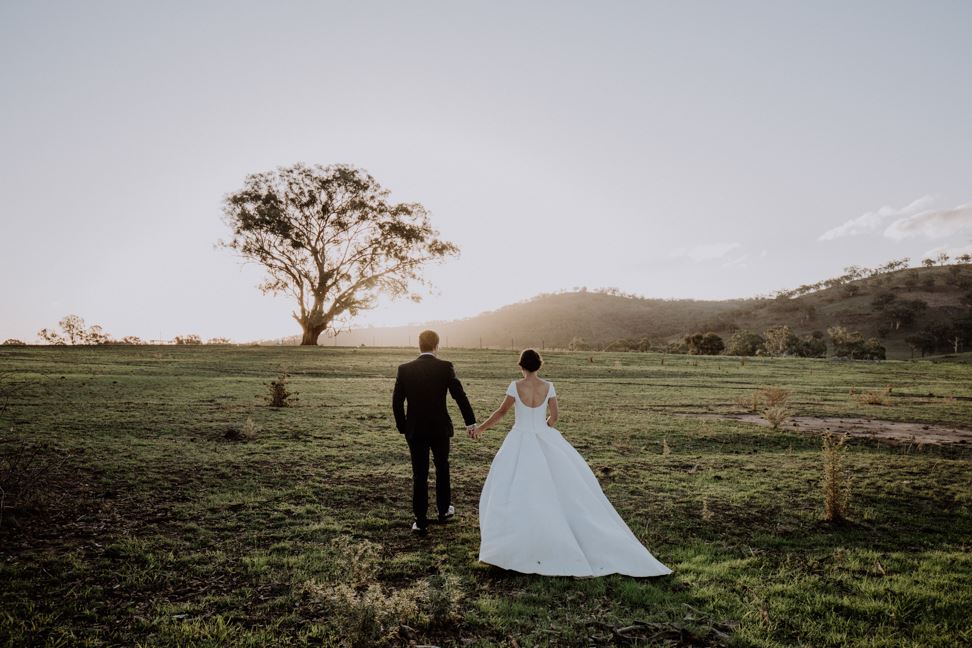 Wedding in the country with a tree and mountains.