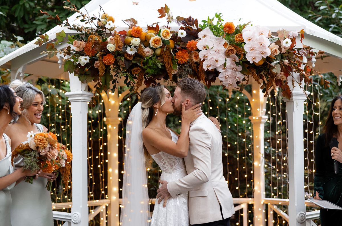 Couple gets married with a gazebo in the background.