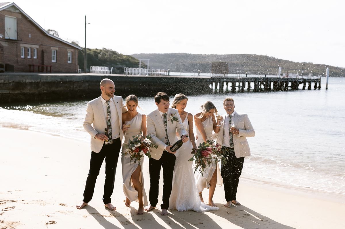 Beach wedding celebration with champagne and bridal party