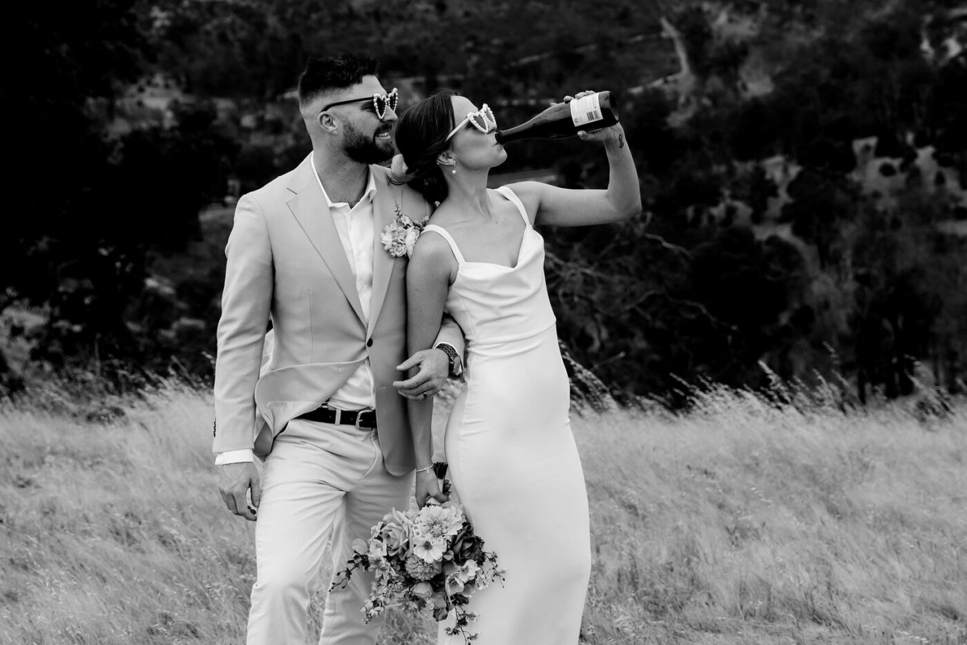 post-wedding black and white image bride drinking wine