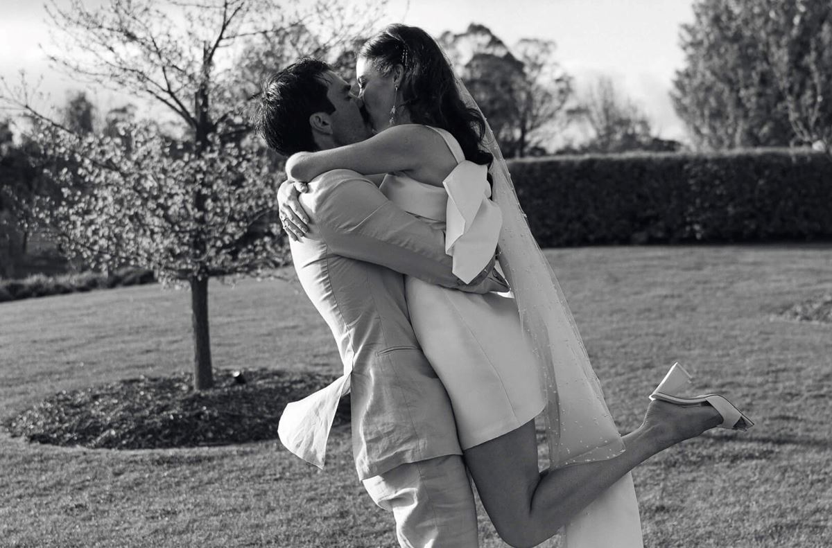 black and white pic of bride jumping into grooms arms