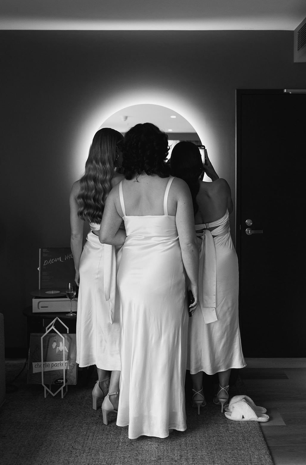 black and white image of bride getting her shoe fixed
