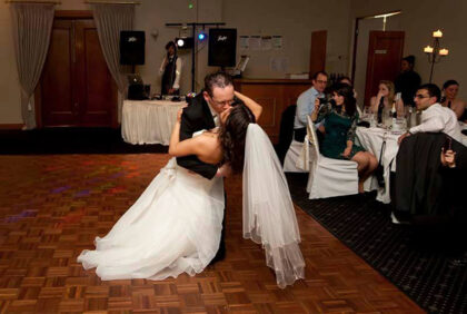 a couple kisses at their first wedding dance