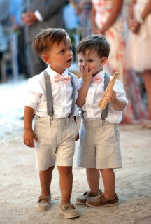 two cute page boys at wedding wearring shorts and suspenders