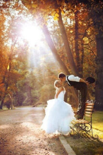 groom standing on a bench kissing the bride