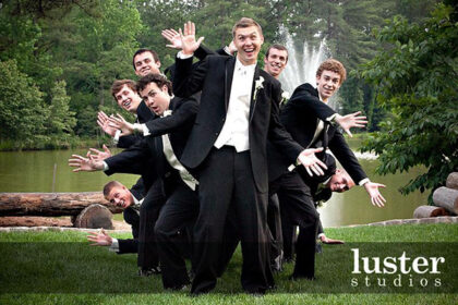 groom and groomsmen in black suits being happy