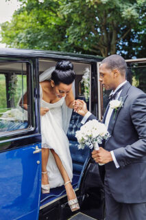 groom helps the bride to get off the car
