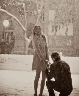 a guy is proposing to his girlfriend in the rain