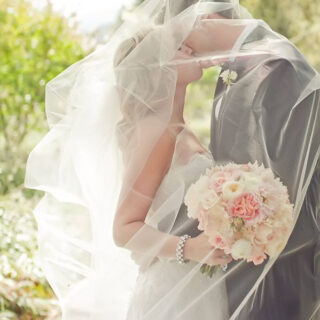 bride and groom kissing under veil