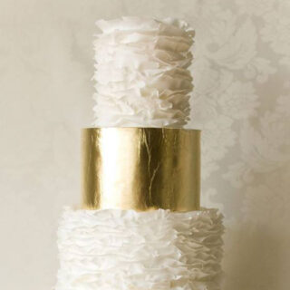 ruffled wedding cake with golden bands|
