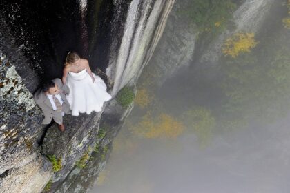 |A couple perched on a cliff face for their extreme wedding photos. Image: Philbrick Photography|||A couple perched on a cliff face for their extreme wedding photos. Image: Philbrick Photography